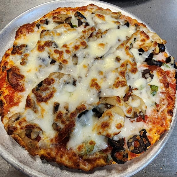 Alvino's Pizza with melted cheese, mushrooms, and black olives on a metal tray.